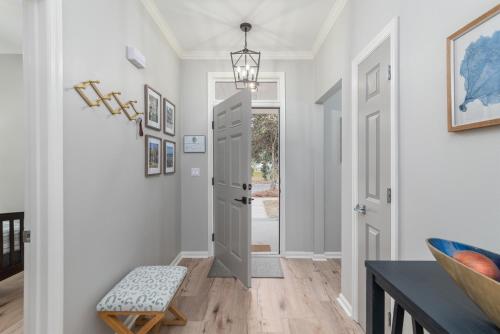 a hallway with a door and a table and a stool at Encanto of the Lowcountry in Old Town Bluffton in Bluffton