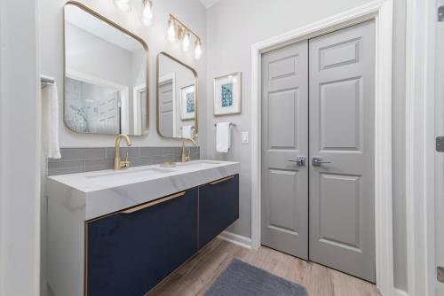 a bathroom with a double sink and two mirrors at Encanto of the Lowcountry in Old Town Bluffton in Bluffton