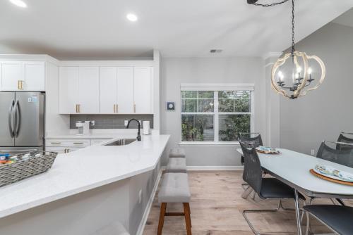 a kitchen with white cabinets and a table with chairs at Encanto of the Lowcountry in Old Town Bluffton in Bluffton