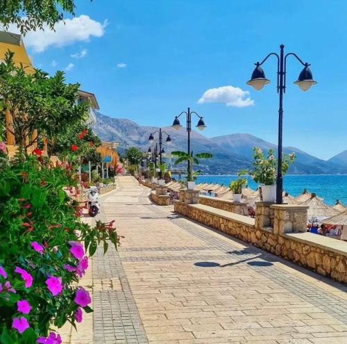 a street next to the water with flowers at Sevilia Rooms in Qeparo