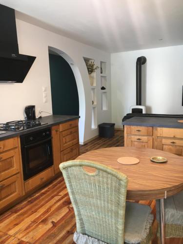 - une cuisine avec une table en bois et une cuisinière dans l'établissement Petite maison avec jardin privé, au Malzieu-Ville