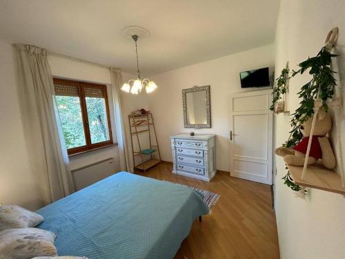 um quarto com uma cama azul, uma janela e uma cómoda em Nido di Rina em Ponte A Bozzone