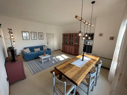 uma sala de estar com uma mesa e um sofá azul em Nido di Rina em Ponte A Bozzone