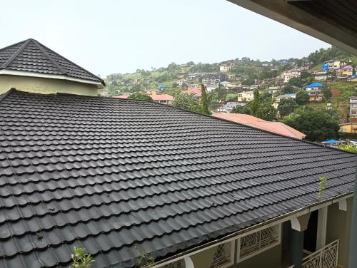 a tile roof on a building with a city in the background at Himma's Apartments in Adonkia