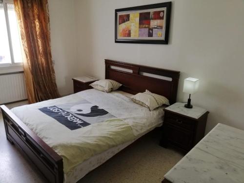 a bedroom with a bed with a sign on it at Ahlem palmeraies résidence in La Marsa
