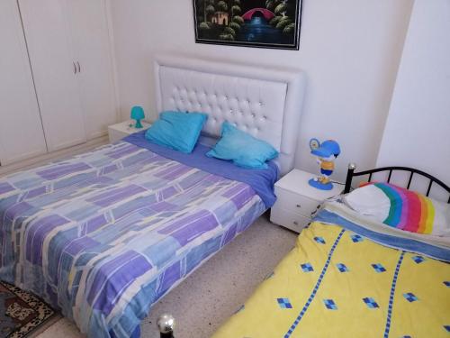 a bedroom with a bed with blue pillows at Ahlem palmeraies résidence in La Marsa