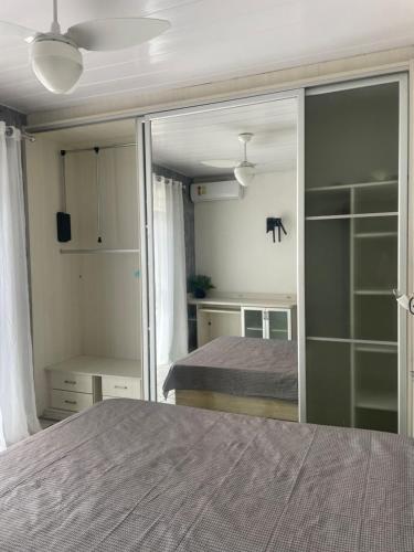 1 dormitorio con 1 cama y un gran armario de cristal en Casa 2 quartos Praia dos Ingleses e Santinho, en Florianópolis