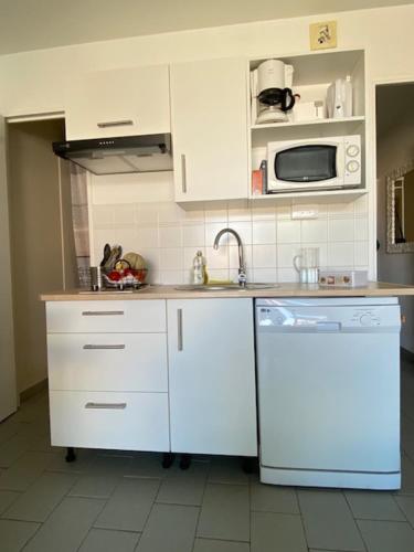 a kitchen with white cabinets and a sink and a dishwasher at Escapade à Pornichet/Wi-fi/Parking/Bord de Mer in Pornichet