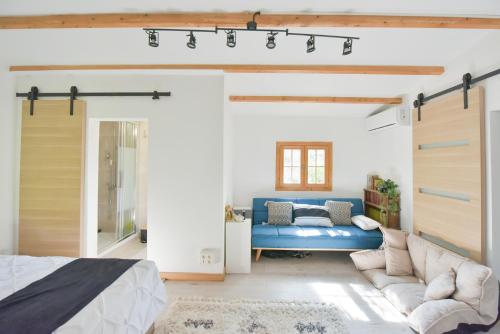 1 dormitorio con sofá azul y cama en Wood Chalet 1 Monaco Forest La Turbie - Sleeps 5 people, en La Turbie