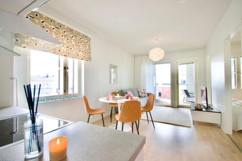 uma cozinha e sala de estar com mesa e cadeiras em Nordic Quality Apartments- Feel the North em Rovaniemi