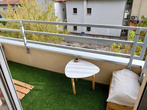 uno sgabello bianco su un balcone con erba verde di Charmant Duplex aux Minimes a Tolosa