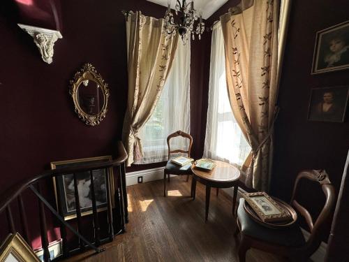 ein Wohnzimmer mit einem Tisch, Stühlen und einem Fenster in der Unterkunft THE RED STAR ROOM A in Niagara Falls