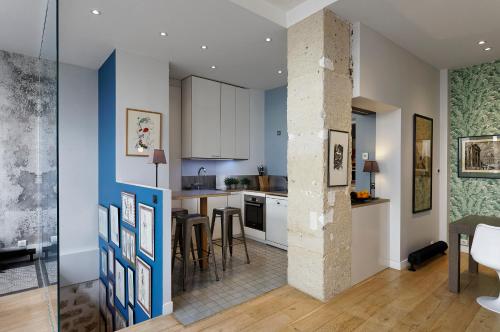 une cuisine avec des murs bleus et blancs et une table dans l'établissement 4-bedroom apartment in Latin Quarter, à Paris
