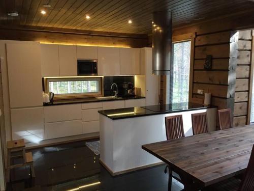 cocina con mesa de madera y encimera en Charming log house - Lumous B - Pyhätunturi - Finland, en Pyhätunturi