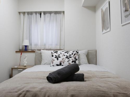 a bedroom with a large bed with a pillow on it at Duo Scala Shinjuku 東新宿 in Tokyo