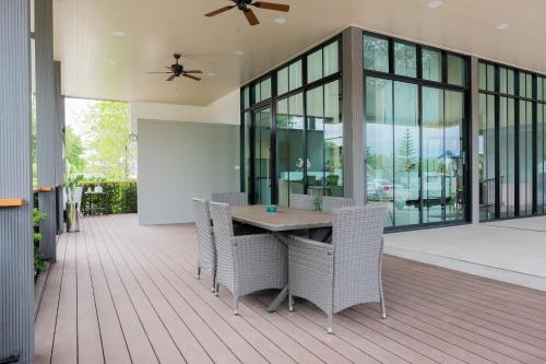 a patio with a table and chairs on a deck at Wellington Hotel Prachuapkhirikhan in Ban Nong Bua