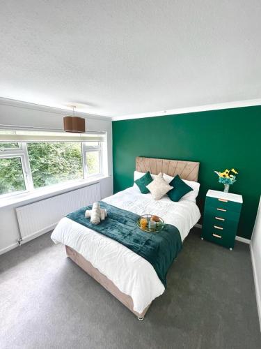 um quarto com uma cama grande e uma parede verde em White House Villa em Nottingham