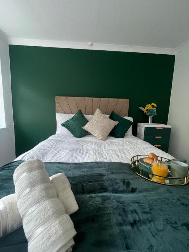 um quarto com uma cama grande e uma parede verde em White House Villa em Nottingham
