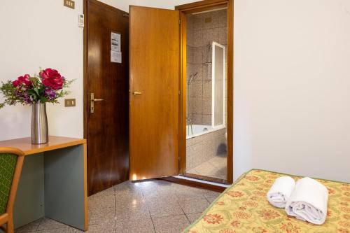 a bedroom with a bed and a vase of flowers at Camelia Rooms Venice Guesthouse in Mestre