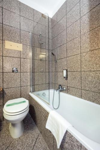 a bathroom with a toilet and a bath tub at Camelia Rooms Venice Guesthouse in Mestre