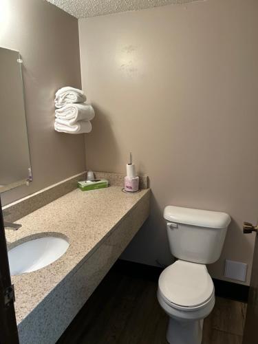 a bathroom with a toilet and a sink and towels at Cedar Inn in Lloydminster