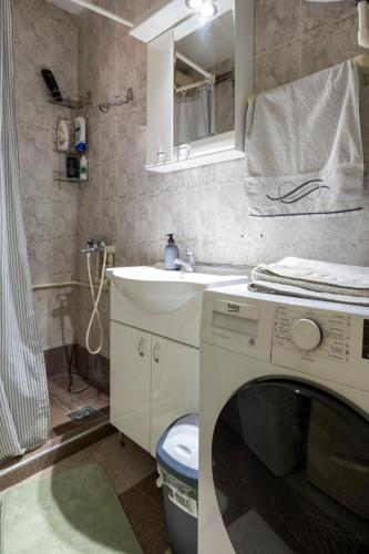 a bathroom with a sink and a washing machine at Apartman Centar in Niš