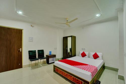 een slaapkamer met een bed en een stoel erin bij Super OYO Flagship Hotel Shakti Inn in Jamshedpur