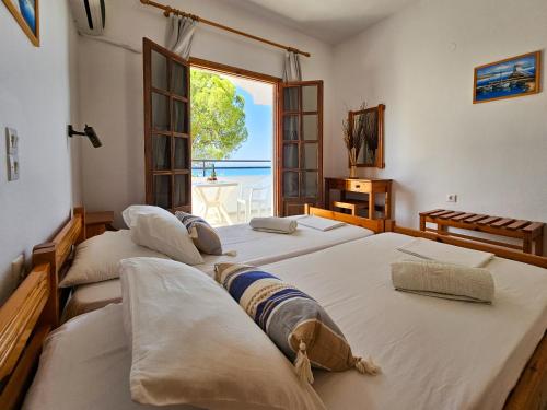 3 camas en una habitación con vistas al océano en George Seaside Serviced Studios & Apartments en Pefki Rhodes