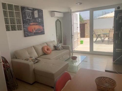 ein Wohnzimmer mit Sofa und Tisch in der Unterkunft Apartamento in Sanlúcar de Barrameda