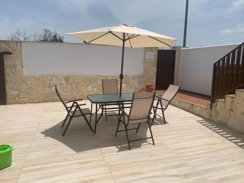 ein Tisch und Stühle mit einem Sonnenschirm auf einer Terrasse in der Unterkunft Apartamento in Sanlúcar de Barrameda