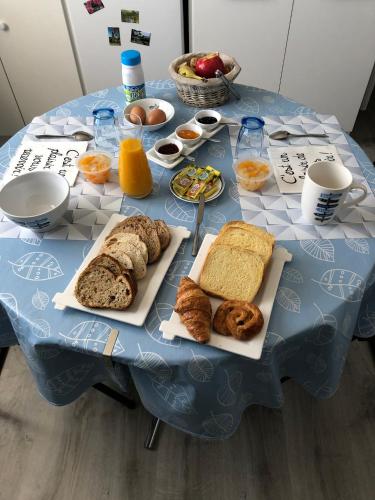una mesa azul cubierta con platos de pan y bollería en Chez Annie, en Doué-la-Fontaine