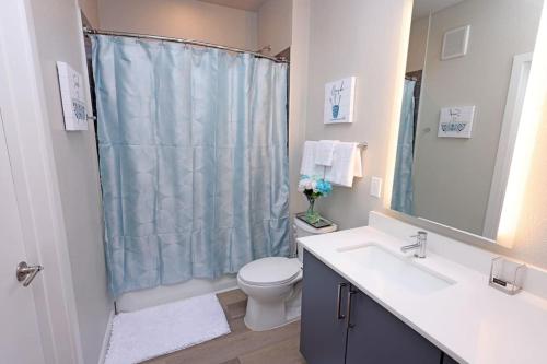 a bathroom with a toilet and a sink and a shower at Comfortable Getaway Downtown Htx in Houston