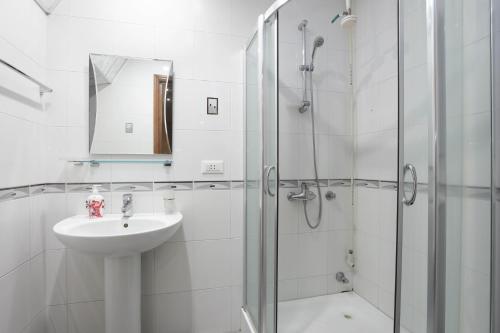 uma casa de banho branca com um lavatório e um chuveiro em AM Apartments 5 em Yerevan