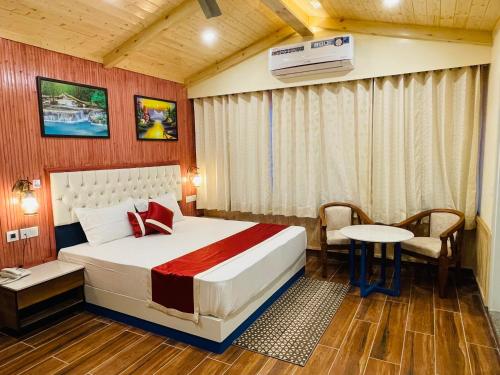 a hotel room with a bed and a table and a desk at Hotel Wood Stock Luxury - A Boutique Property - Penthouse - Open Air Restaurant & Terrace in Kasauli