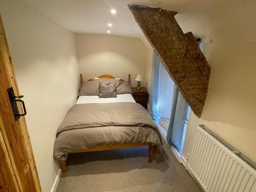a bedroom with a bed in a small room at Large Historic Farmhouse in Rhondda Valley Perfect for Groups with Hot Tub in Blaencwm