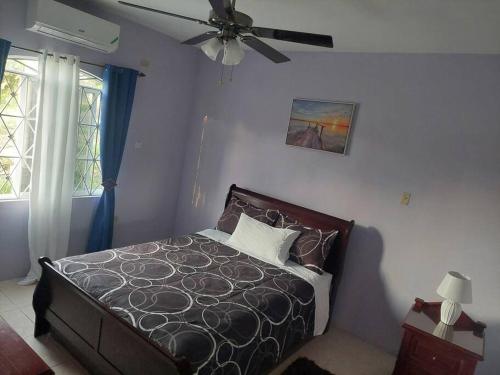 1 dormitorio con 1 cama y ventilador de techo en MB's Chillspot en Saint Annʼs Bay