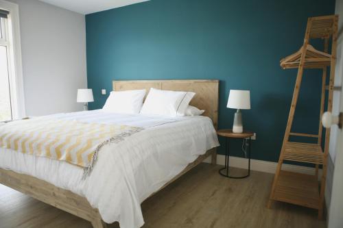 1 dormitorio con 1 cama con pared azul en Ocean Breeze en Cork