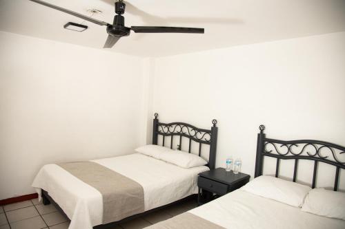 a bedroom with two beds and a ceiling fan at Marqués Oaxaca - Hotel in Oaxaca City