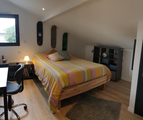 une chambre avec un lit, un bureau et une chaise dans l'établissement Villa à Biarritz avec une terrasse un SPA et parking, à Biarritz