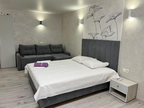 sypialnia z dużym łóżkiem i kanapą w obiekcie бул. Шевченка 352, квартира-студія w Czerkasach