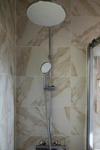 a shower with a shower head in a bathroom at ELMAR ARTemida in Artemida