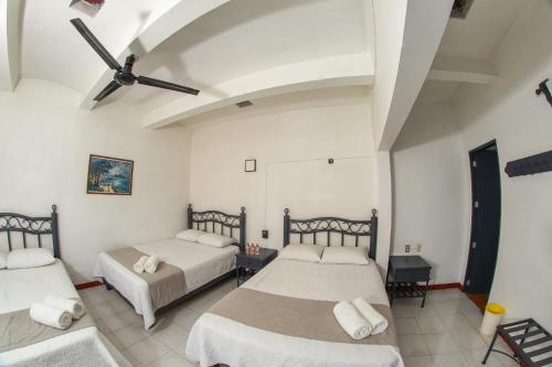 a bedroom with two beds and a ceiling at Marqués Oaxaca - Hotel in Oaxaca City