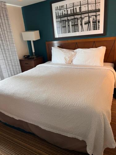 Bett mit weißer Bettwäsche und Kissen in einem Zimmer in der Unterkunft Queen bed available in Mississauga