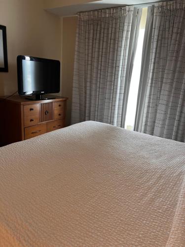 a bedroom with a bed and a flat screen tv at Queen bed available in Mississauga