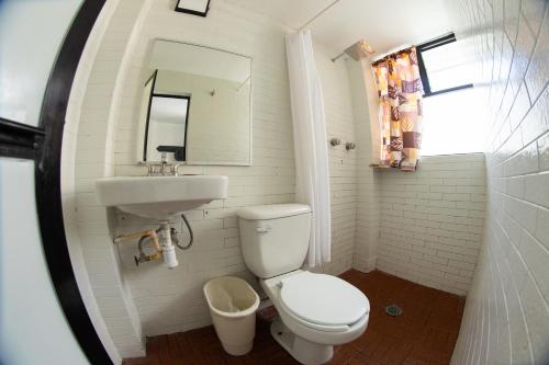 a bathroom with a toilet and a sink and a mirror at Marqués Oaxaca - Hotel in Oaxaca City