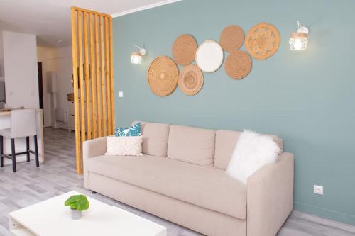 - un salon avec un canapé et des assiettes murales dans l'établissement Appartement Moderne et Tropical 15 min Paris, à Juvisy-sur-Orge