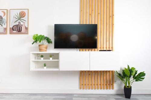 - une télévision sur un meuble blanc dans le salon dans l'établissement Appartement Moderne et Tropical 15 min Paris, à Juvisy-sur-Orge