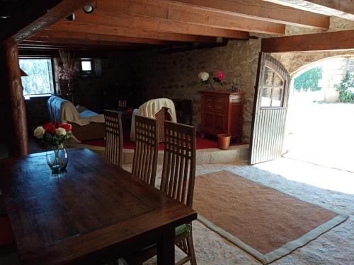 Félines的住宿－Les chambres de Solol，一间带木桌和椅子的用餐室