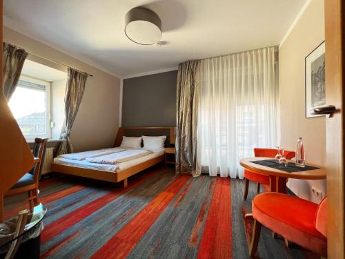 ミュンヘンにあるホテル プリンツのベッドとテーブルが備わるホテルルームです。
