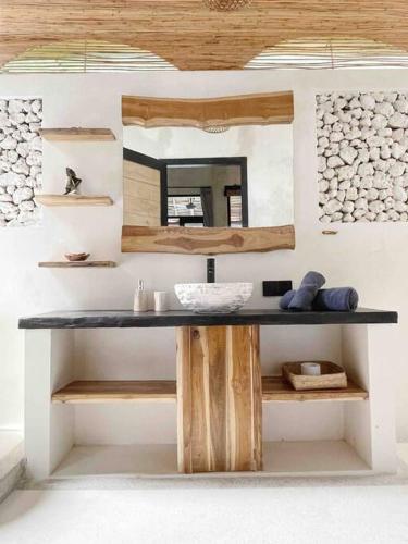 a bathroom with a table with a mirror on it at Angatu Villas 2 Padang Padang in Uluwatu